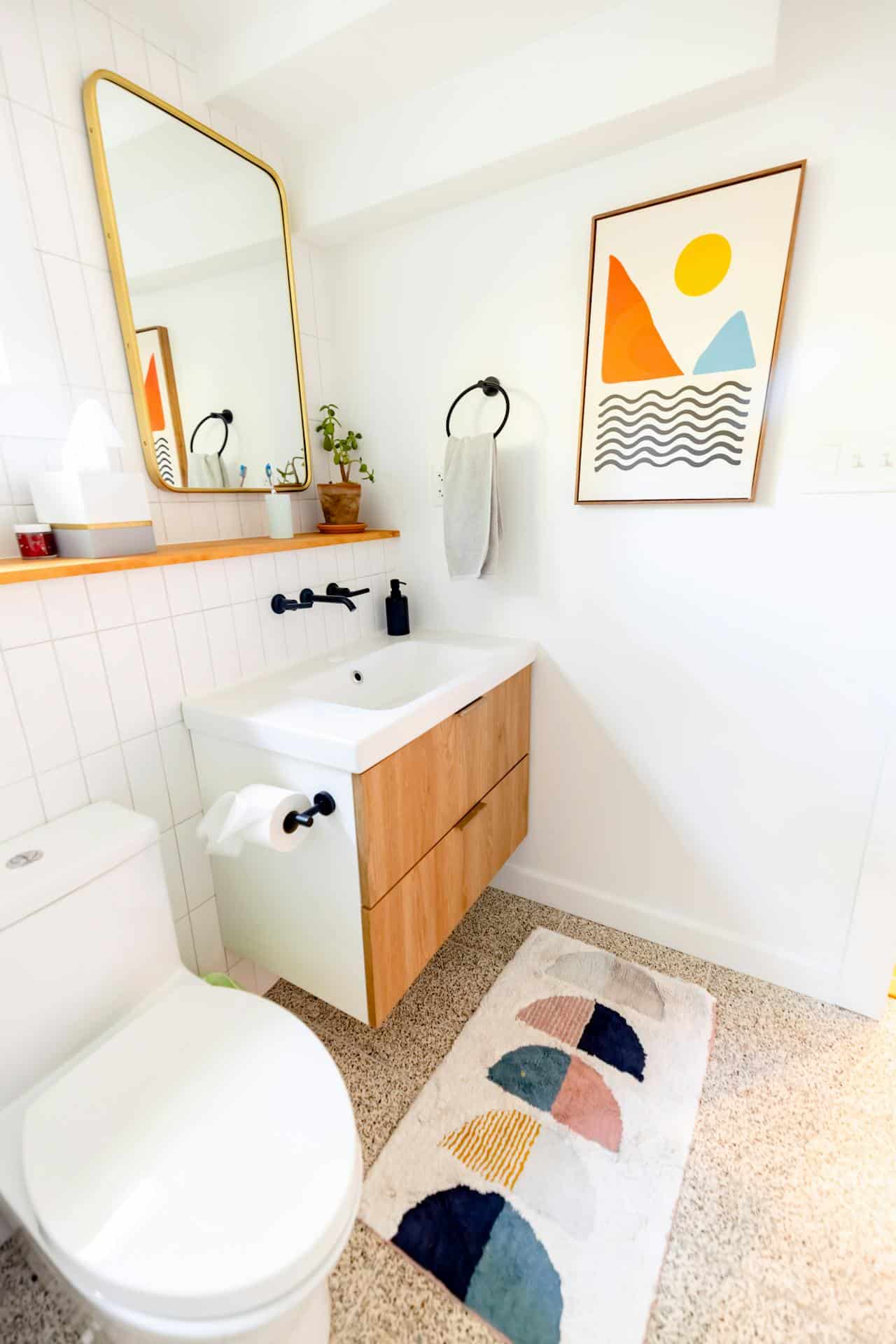 Bathroom with a wood vanity, round mirror, matte black fixtures and clear floor space