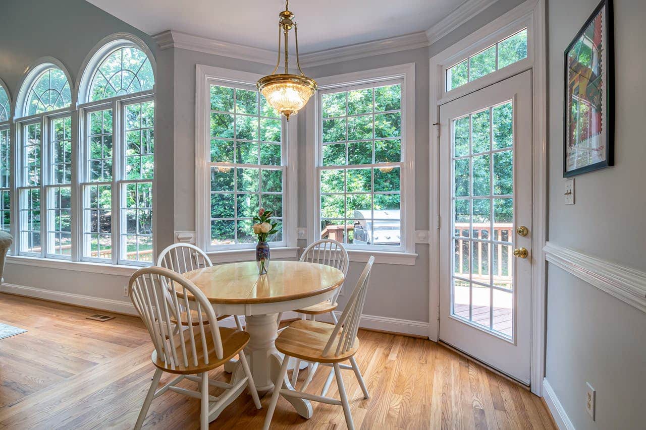 Breakfast nook set in a bay window with a table and chairs looking onto greenery